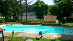 A swimming pool with two lounge chairs and a small plant. - Spacious Mobile Home with Terrace - 6 Pers. (Rochechouart)