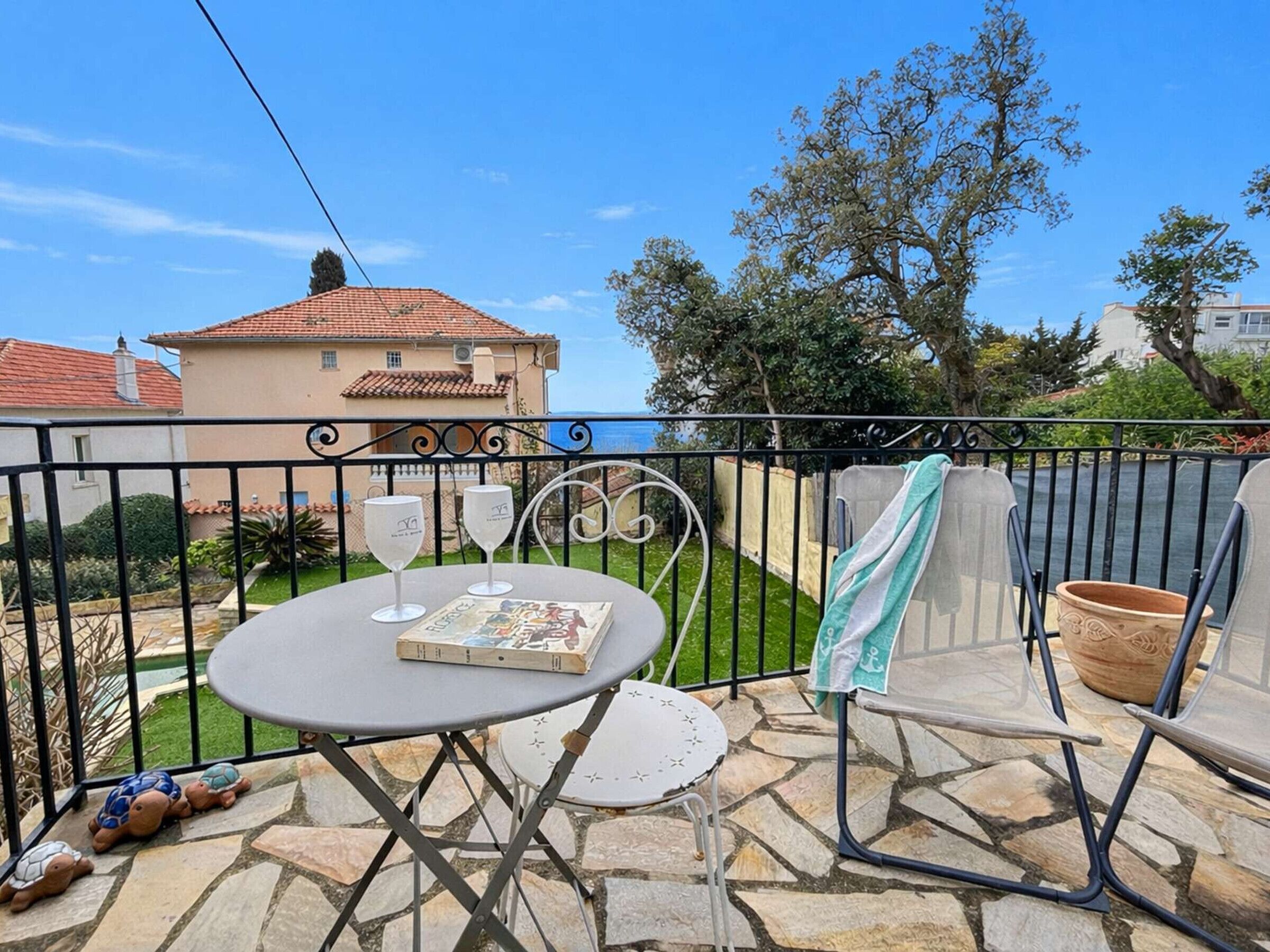 A patio with a table, chairs, and a book.
