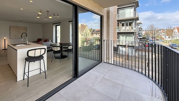 A modern apartment with a kitchen, dining area, and a balcony with a view of the neighborhood. - Flat Seadune - De Panne (De Panne)