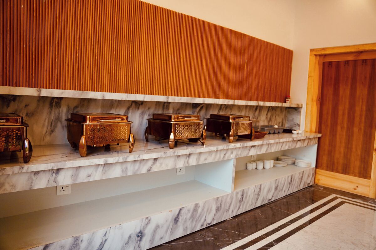 A marble countertop with storage boxes, a wooden panel wall, and a door.