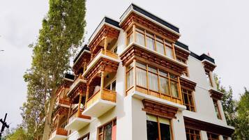 Un edificio de varios pisos con balcones, ventanas amplias y un estilo arquitectónico tradicional.