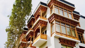 A multi-story building with balconies and large windows. - Hotel Walnut Ladakh (Leh)