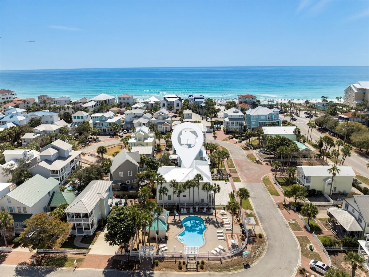 A coastal residential area with a large white building featuring a prominent circular design element.