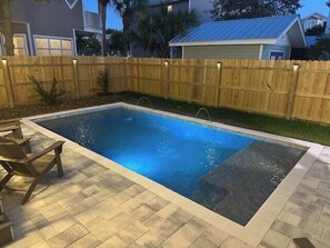 Ein rechteckiger Swimmingpool, umgeben von einem Holzzaun.