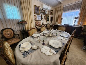 A dining room with a round table set for a meal, surrounded by ornate chairs. - THE SUMMER PLACE BOUTIQUE GUESTHOUSE (Bloemfontein)