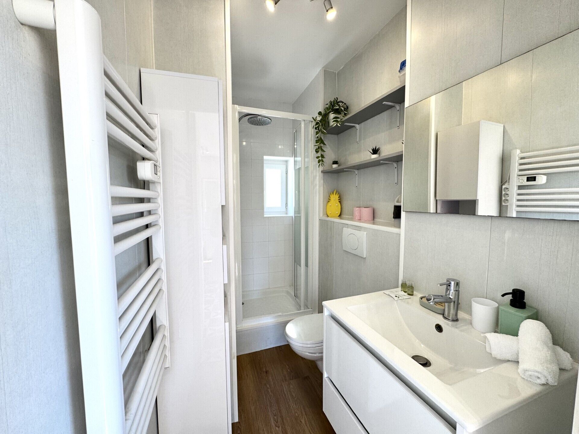 A modern bathroom with a shower, toilet, and sink.