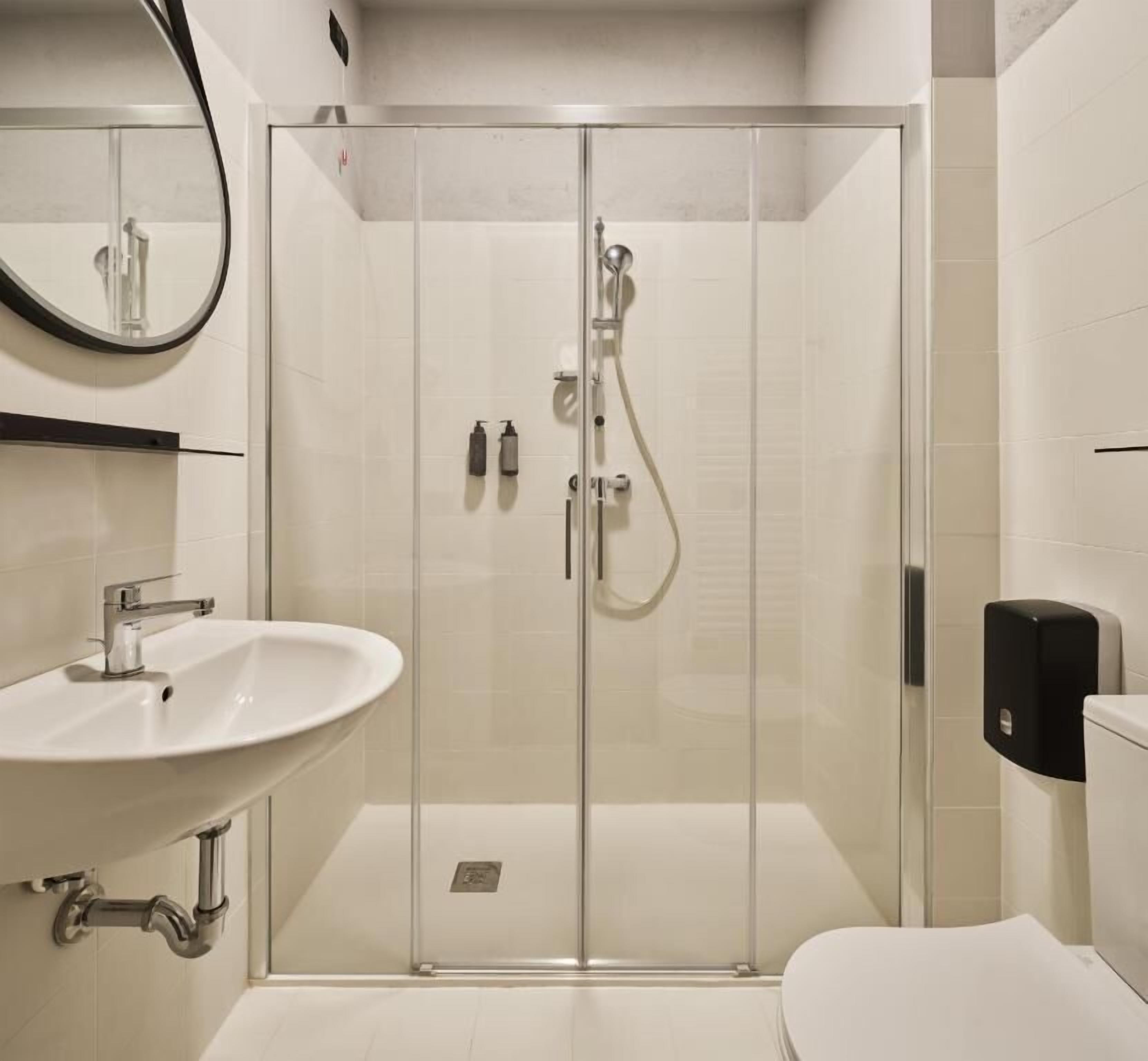 Ein modernes Badezimmer mit einer Duschkabine, einem Waschbecken und einer Toilette.
