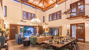 A spacious dining area with a high ceiling, wooden beams, and a large chandelier. - Azara is a serene luxury sanctuary in Goa designed for calm and escape. (Candolim)