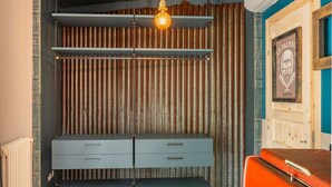 Une pièce avec une commode de style ancien, un radiateur et une valise vintage.