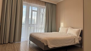 Ein modernes Schlafzimmer mit Bett, Vorhängen und einer Chandelieber.