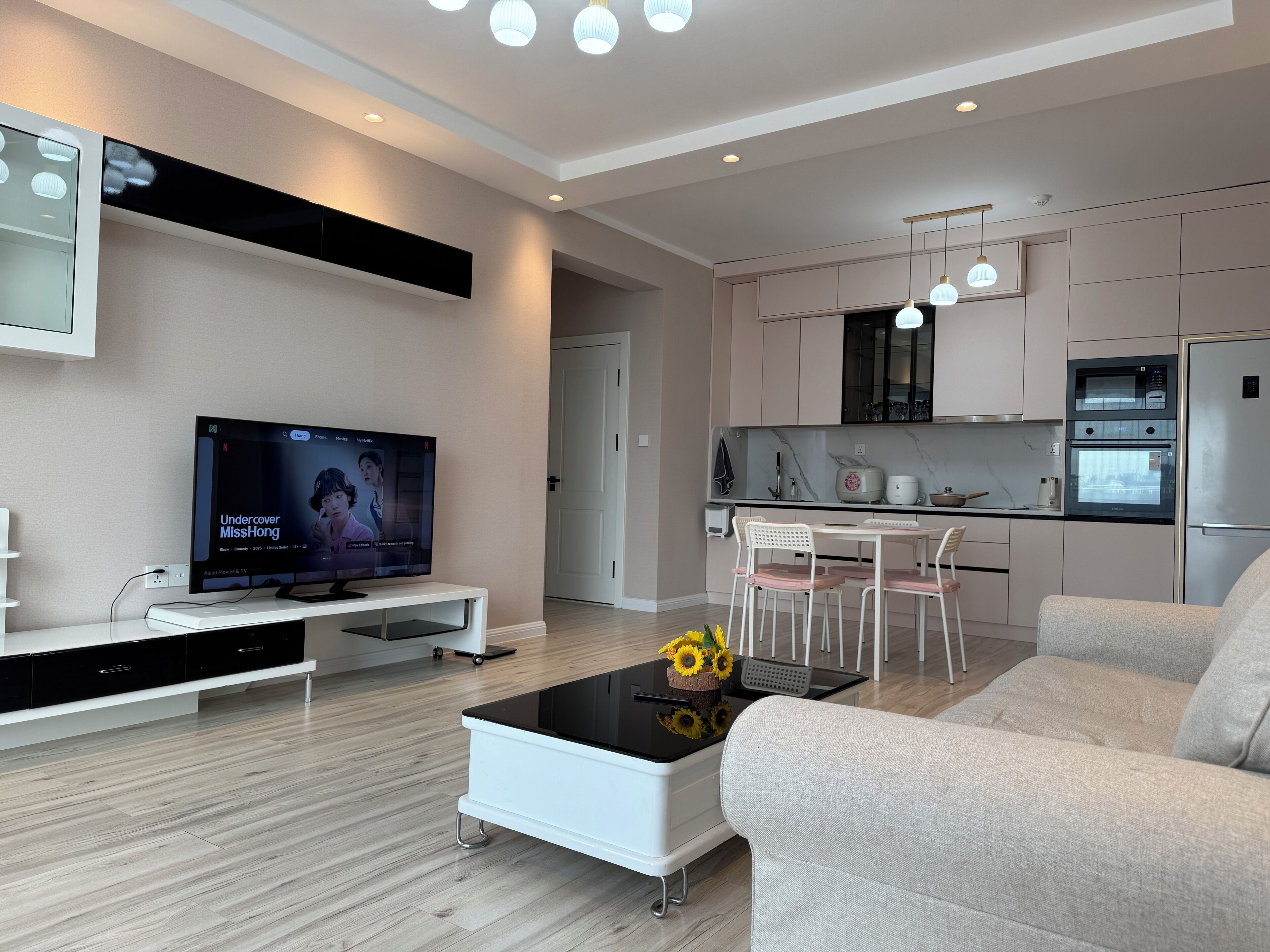 Un salon moderne avec un téléviseur à écran plat, une table basse et un canapé.