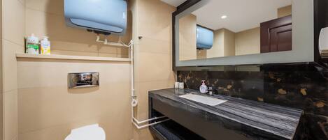 A modern bathroom with a toilet, a sink, a mirror, a television mounted above the sink, and a shelf with toiletries.