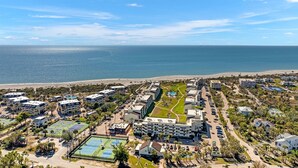 A coastal resort with multiple buildings, a beach, and a tennis court. - Loggerhead Cay 362: Updated Coastal Charm – Steps to Beach with Gulf Views & New (Sanibel)