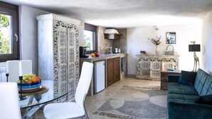 Een compacte keuken met een eethoek, een bank en een decoratieve lamp.