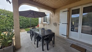 An outdoor patio with a table and chairs, a covered area, and a view of a natural landscape. - U Miu Sognu by Pinarello Villa Services (Sainte-Lucie de Porto-Vecchio)