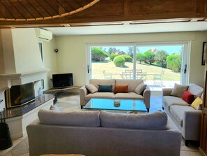 Una sala de estar con un sofá, una mesa de centro, un televisor y una chimenea.