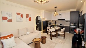 Uma sala de estar moderna com sofá, mesa de centro e área de jantar.