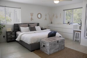 A bedroom with a bed, bedside tables, a dresser, a desk, and a window with blinds. - Rainbow Sky Terrace - Ocean Views & Private Spa (Coolangatta)