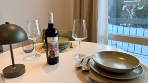 A dining table with a wine bottle, glasses, plates, and cutlery. - Balcony apartment | near the lake | climate | near Bremen (Ganderkesee)
