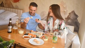 Ein Esstisch mit Sushi, einer Bierflasche und einem Bierglas.