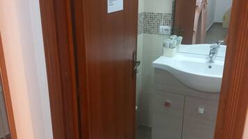 Una porta di legno con un cartello che indica un bagno.