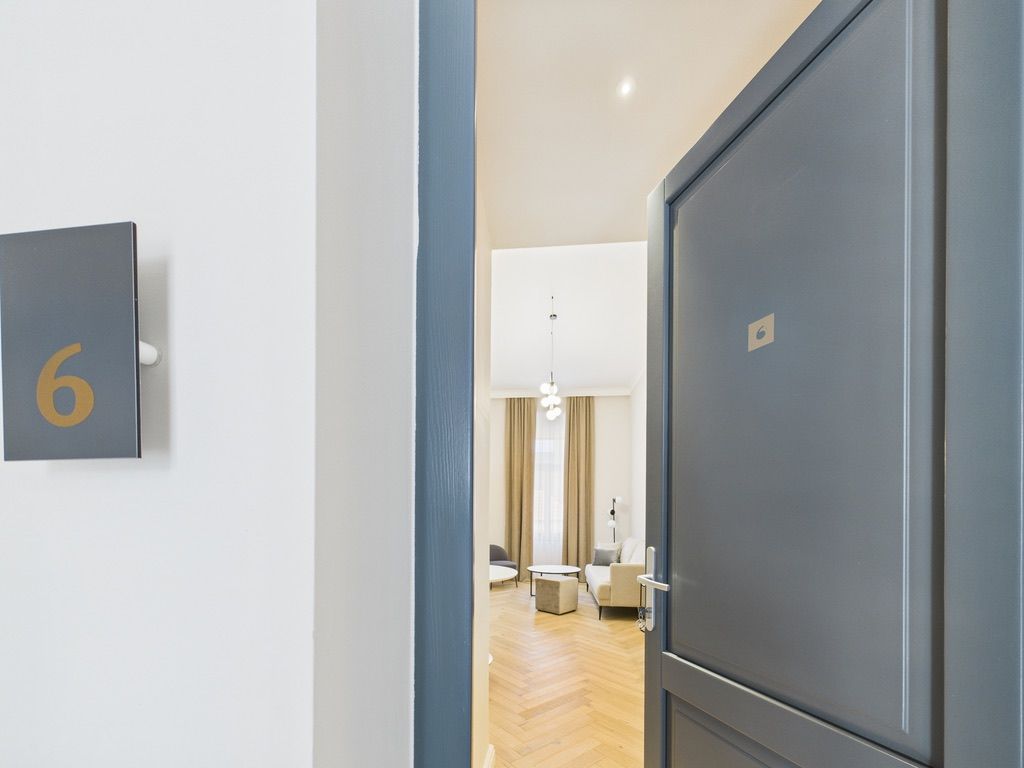 A hallway with a door labeled with the number 6, leading to a room with a modern interior.