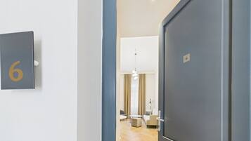 A hallway with a door labeled with the number 6, leading to a room with a modern interior.
