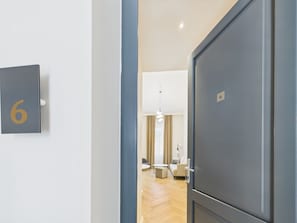 A hallway with a door labeled with the number 6, leading to a room with a modern interior.