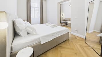 Un dormitorio moderno con cama, mesita de noche y un espejo grande.