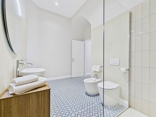 A modern bathroom with a freestanding bathtub, a toilet, and a sink.