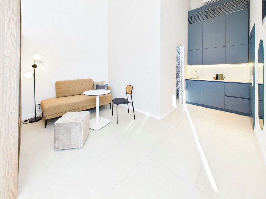A modern interior with a sofa, a round table, and a chair.