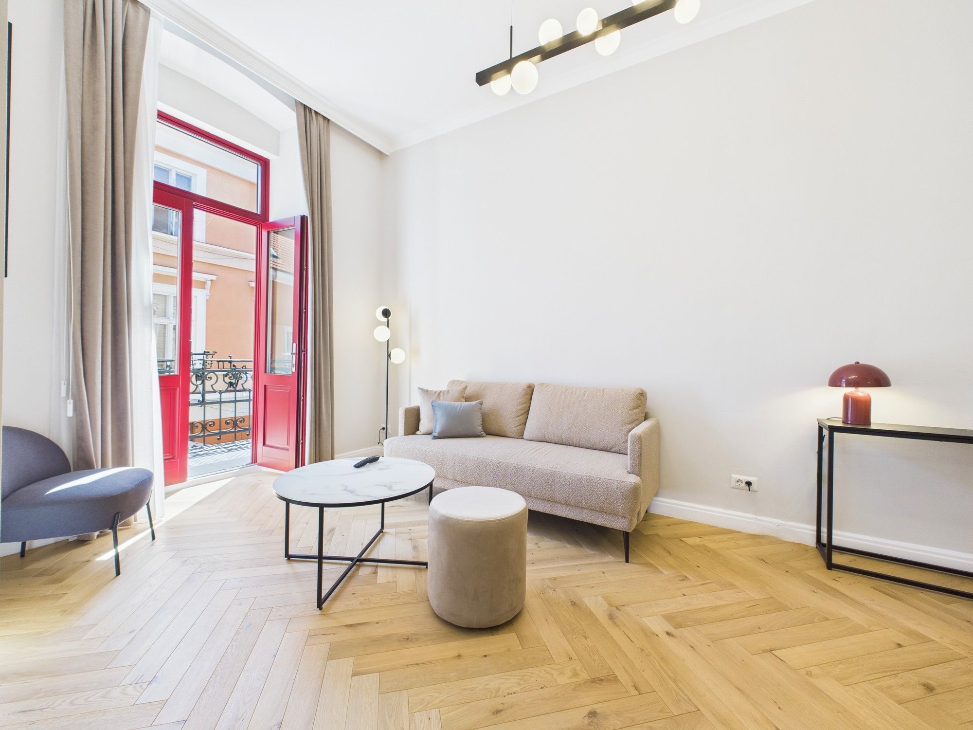 A modern living room with a sofa, a round coffee table, a side table, and a chair.