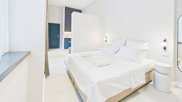 A modern bedroom with a large bed, bedside tables, and a bathroom with a toilet and sink.