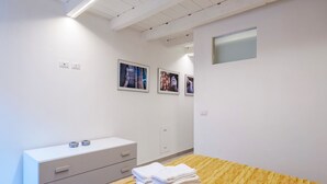 A hotel room with a wooden bed, a white dresser, and three framed pictures on the wall. - Laura's Home (Brescia)