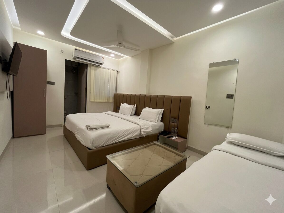 Une chambre d’hôtel moderne équipée de deux lits, d’un téléviseur à écran plat, d’un ventilateur de plafond et d’un appareil de climatisation.