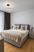 Une chambre à coucher moderne avec un lit, des tables de chevet et un luminaire au plafond.