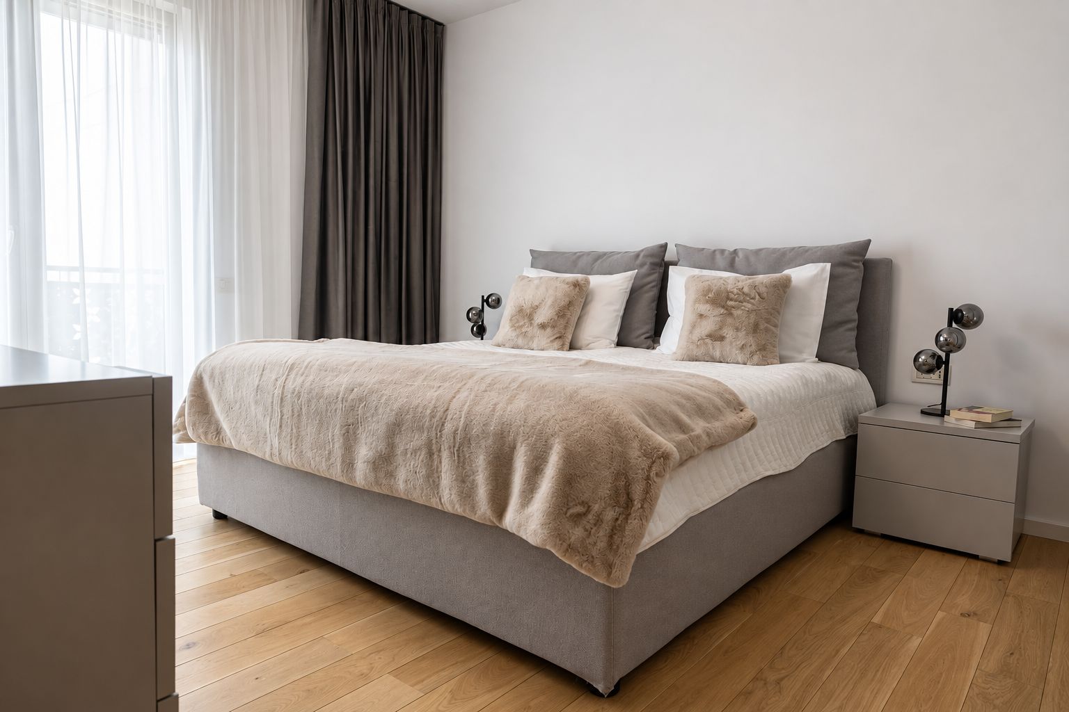 A modern bedroom with a bed, bedside tables, and a nightstand.