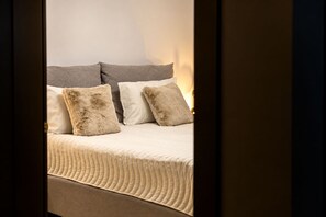 A bed with a headboard, two pillows, and a blanket. - MaisonA (Timișoara)