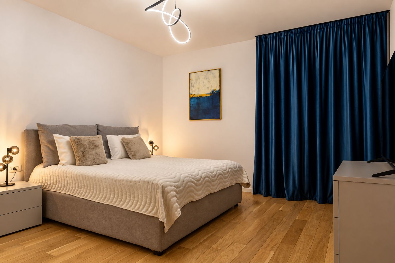 Ein modernes Schlafzimmer mit einem Bett, Nachttischen, einem Schreibtisch und einem Bild an der Wand.