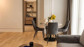 Un salon moderne avec une table basse ronde, un canapé gris et un coin repas comprenant une table et des chaises.
