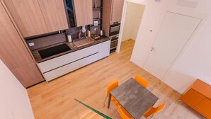 A compact kitchen with a dining area, wooden flooring, and a staircase. - Le Residenze Di Zelo - Private Parking (Mestre)