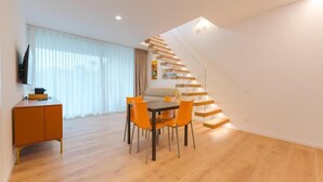 A modern living space with a dining area, a staircase, and a TV mounted on the wall. - Le Residenze Di Zelo - Private Parking (Mestre)