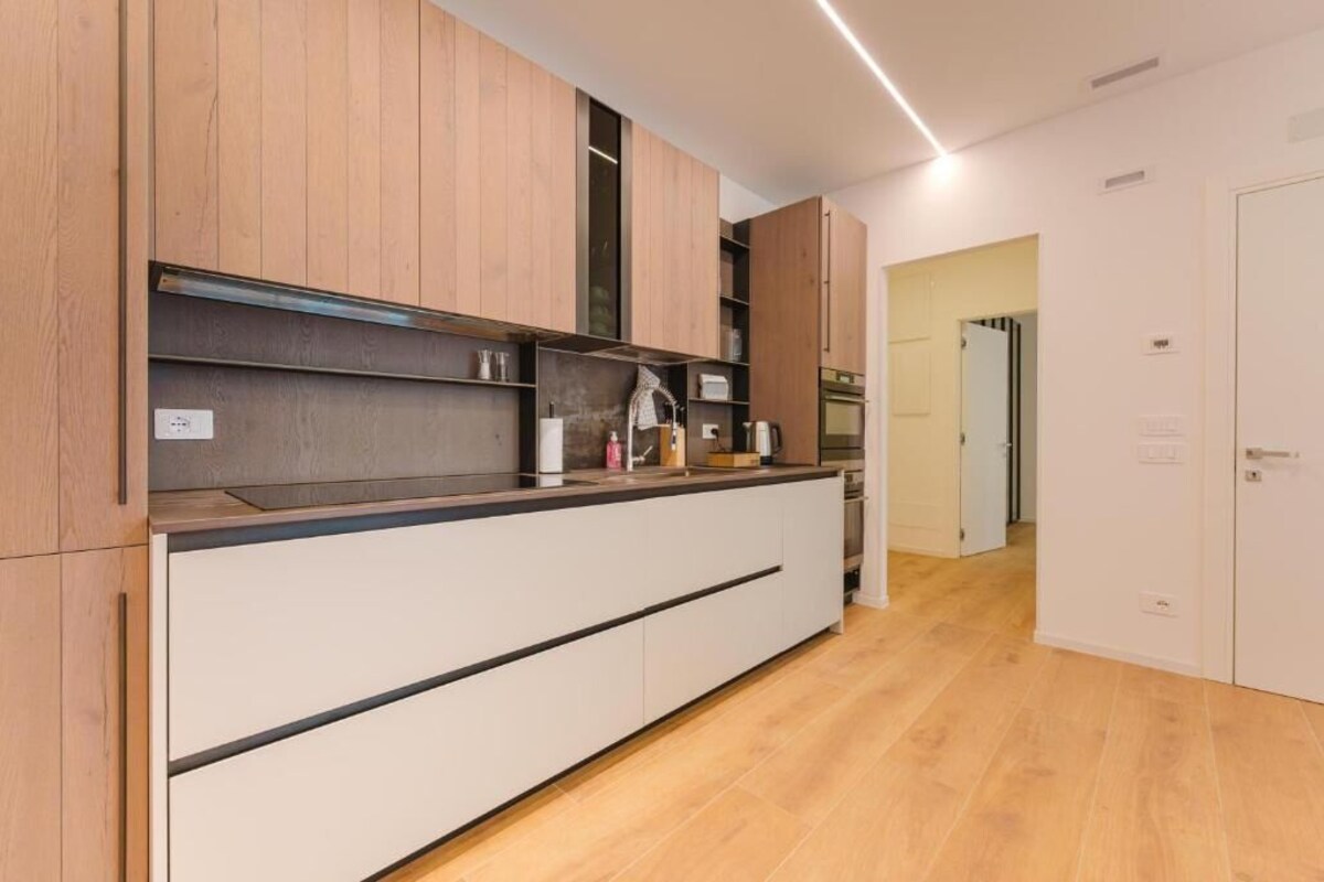 Eine moderne Küche mit Holzausbau, einer Arbeitsplatte und einem eingebauten Backofen.