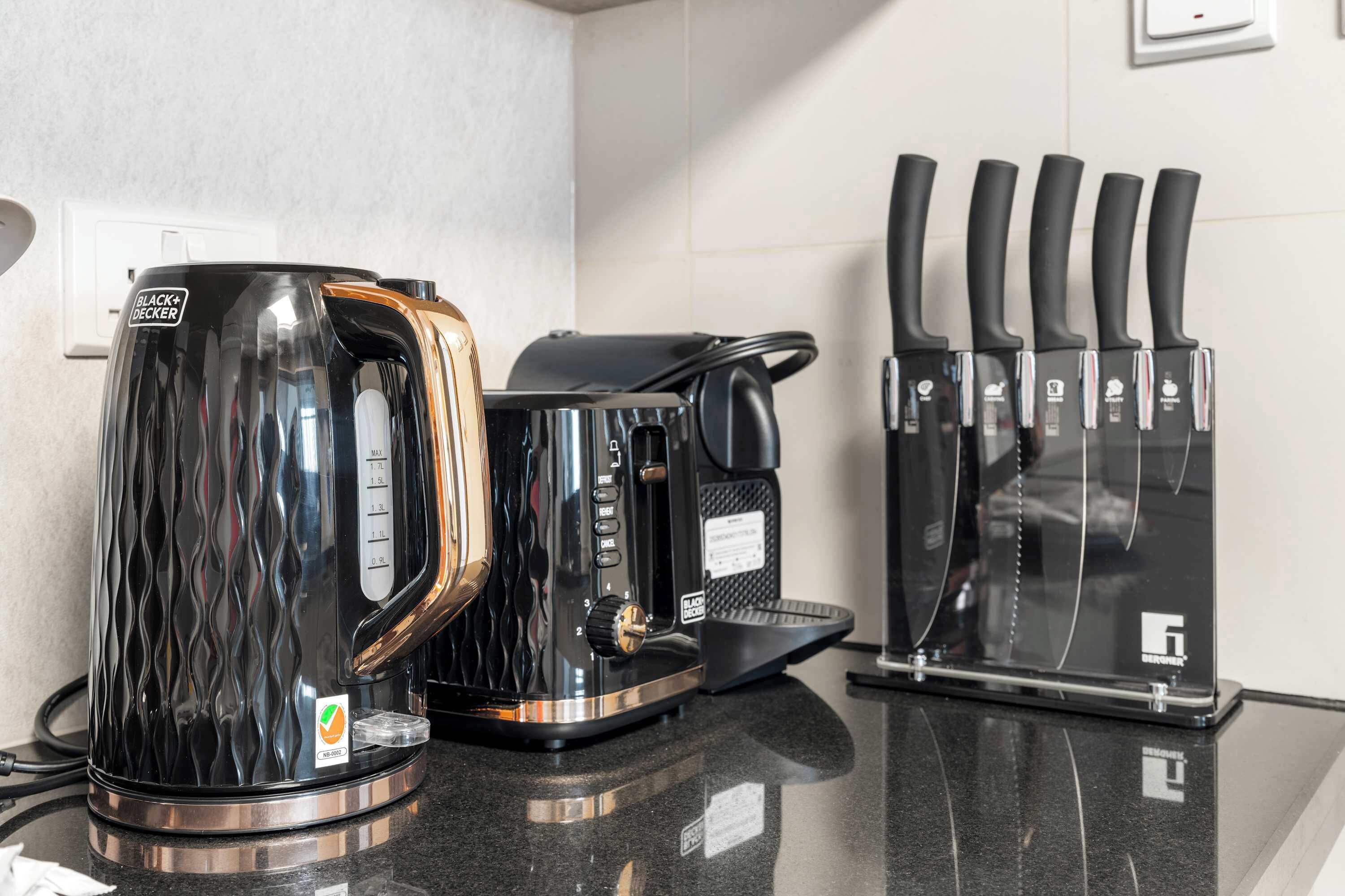 Eine Küche mit Kaffeemaschine, Wasserkocher und einem Messerblock.