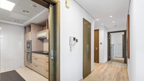 A modern kitchen with built-in appliances, a wooden countertop, and a black rug. - Luxury 2BR in Downtown Dubai, Near Burj Khalifa (Downtown)