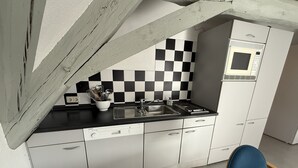 Une cuisine avec un crédence à carreaux, un évier, un lave-vaisselle et un four à micro-ondes.
