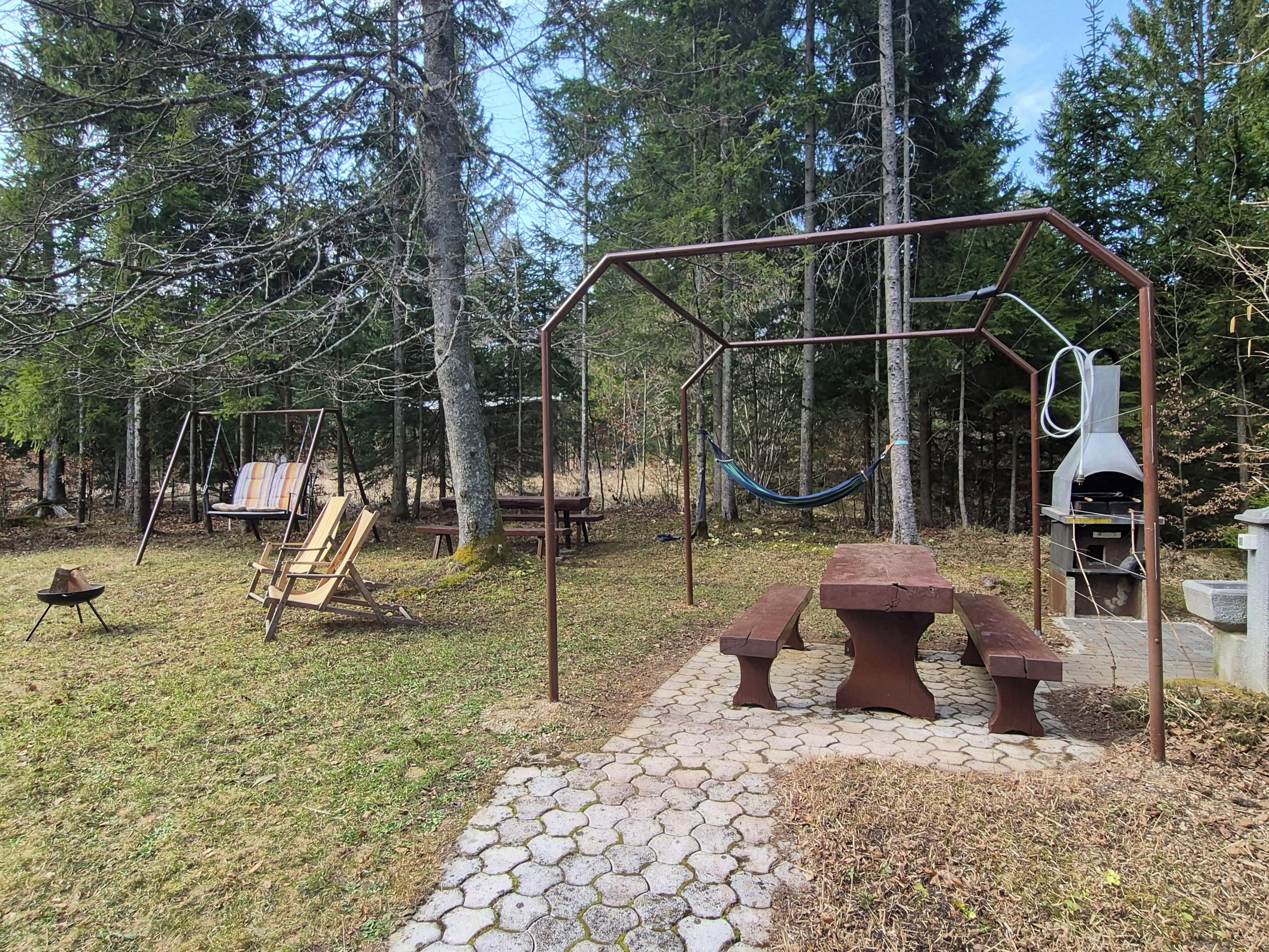 Picnicområde med gyngestativ, hængekøje og grill.