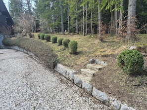 A gravel driveway leading to a building with a wooden deck.