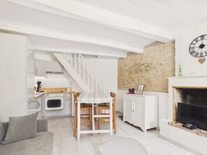Eine Küche mit Essbereich, einer Treppe, einer Steinwand und einem Kamin.
