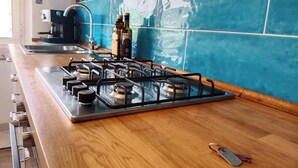 A kitchen with a gas stove, wooden countertop, and blue-tiled backsplash. - Casa Blu • Thermal Relax in the Center • Free Wi-Fi • 15 min. to the sea (Venturina Terme)